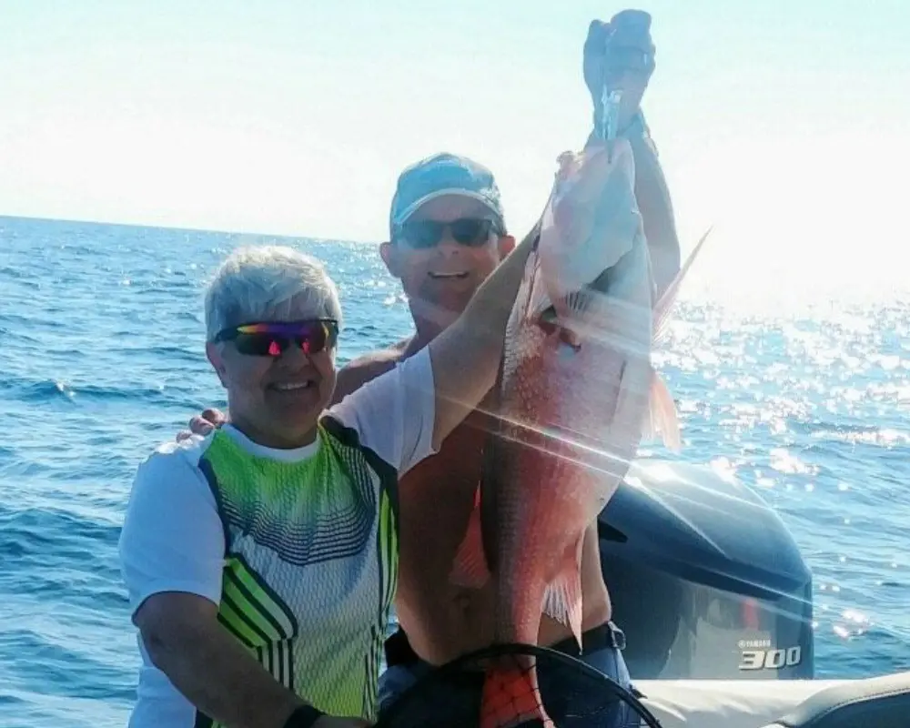 A couple going fishing and holding a fish